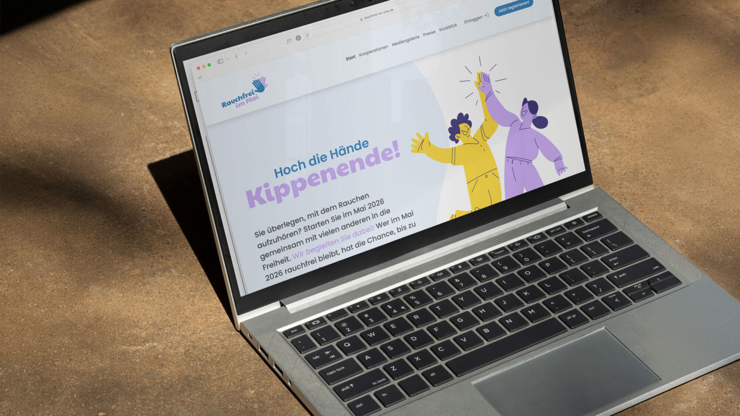 Ein Laptop-Mockup zeigt die Website der Kampagne „Rauchfrei im Mai“ mit der Überschrift „Hoch die Hände Kippenende!“.